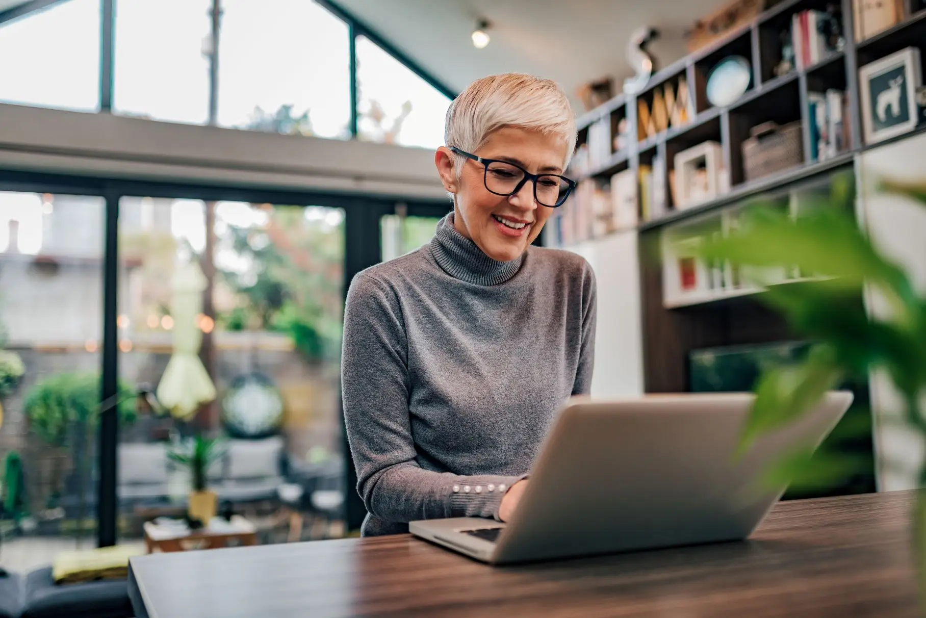 Portrait of a cheerful mature businesswoman working on laptop at home office